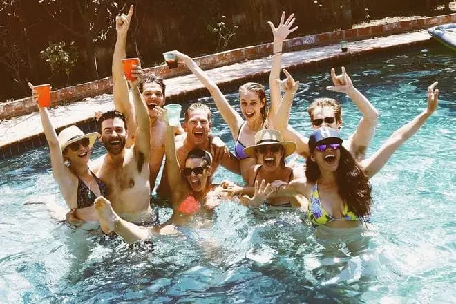Seite Spara in einem Badeanzug mit Freunden im Pool